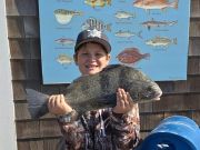Small boy holds up a black drum