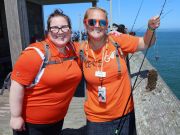 Two tour guides smiling with one fish on pier